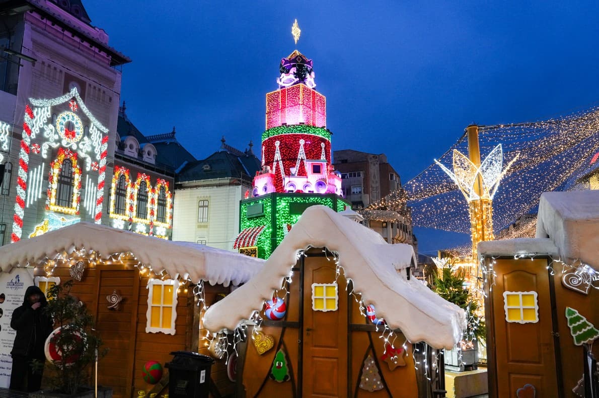 Căsuță de turtă dulce și turn luminat, seara, la Târgul de Crăciun Craiova