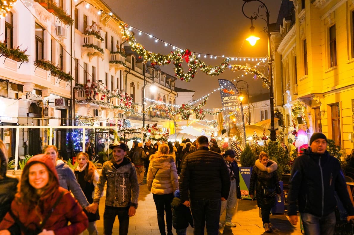 Stradă pietonală decorată festiv, plină de vizitatori, la Târgul de Crăciun Craiova